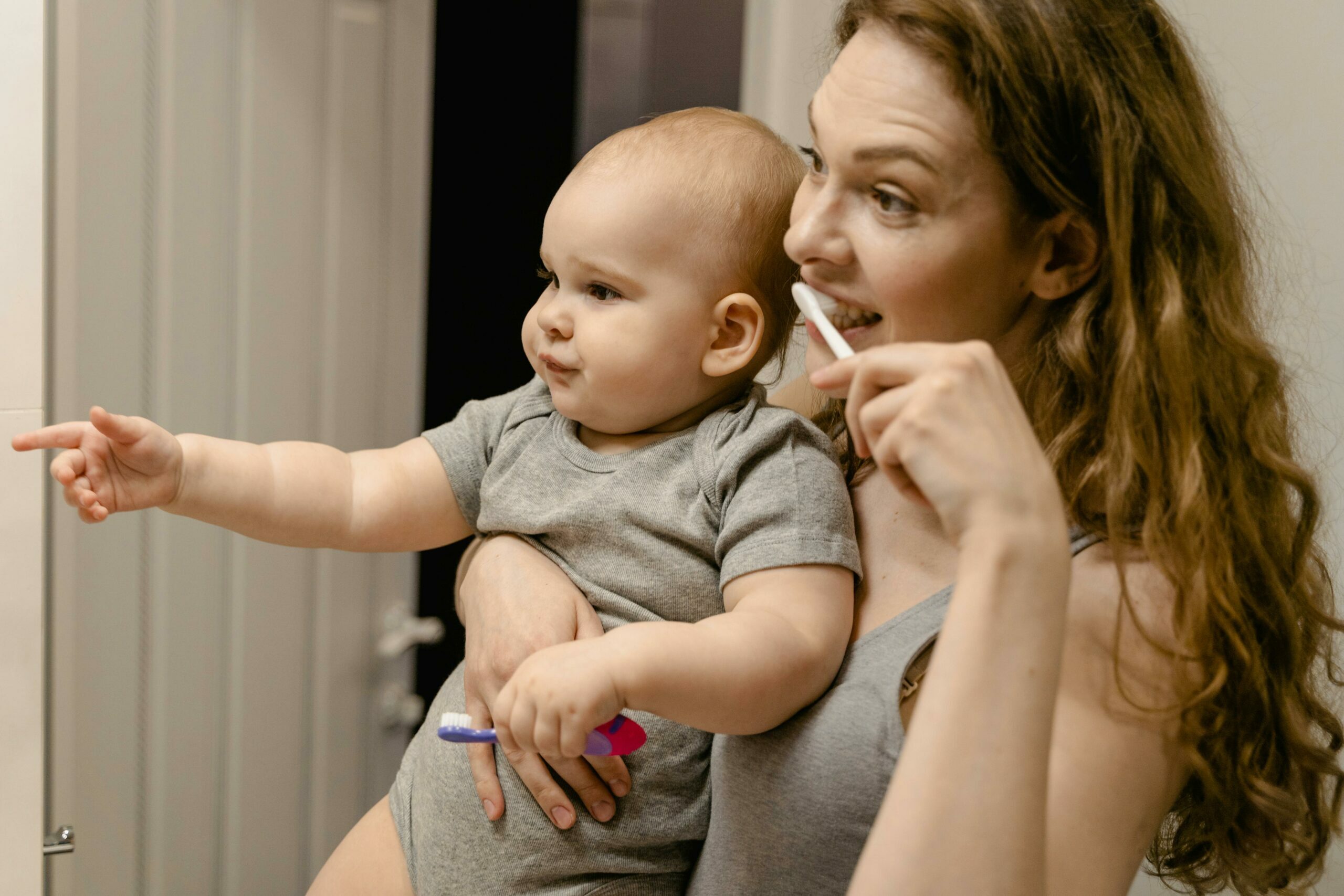 La mère brosse les dents avec sa mère